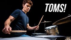 a young man playing drums with the words toms on it's back ground