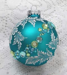 a blue ornament with green and white flowers on it