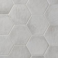 white hexagonal tiles are arranged on the wall in this pattern, which looks like they have been made out of cement