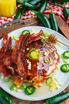 a white plate topped with pancakes covered in bacon and jalapenos