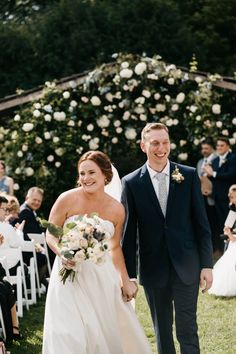 a bride and groom walking down the aisle after their wedding ceremony at an outdoor venue