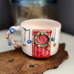 a red and white coffee cup sitting on top of a wooden table