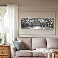 a living room filled with furniture and a painting on the wall above it's windows