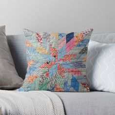 a colorful quilted pillow sitting on top of a couch