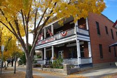 an old brick building with white balconies on the second story and porches