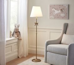 a living room with a chair, lamp and stuffed animal on the window sill