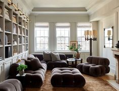 a living room filled with lots of furniture and bookshelves next to a fire place