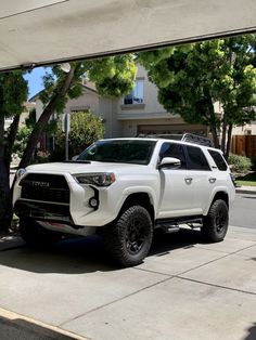 a white truck is parked on the side of the road in front of a house