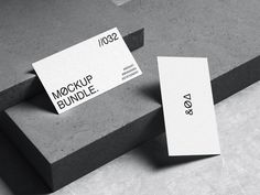 two business cards sitting on top of some concrete blocks with the words mock up bundle