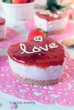 a heart - shaped cake with the word love written on it sits on a doily