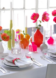 the table is set with pink and orange flowers