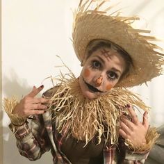 a woman dressed in scarecrow clothes and a straw hat