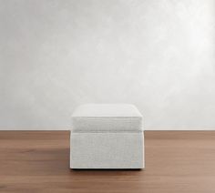 a white ottoman sitting on top of a wooden floor