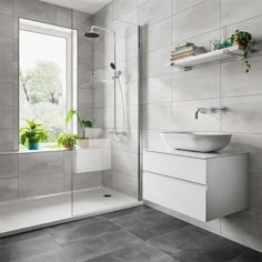 a bathroom with a sink, mirror and shower stall in grey tiles on the wall