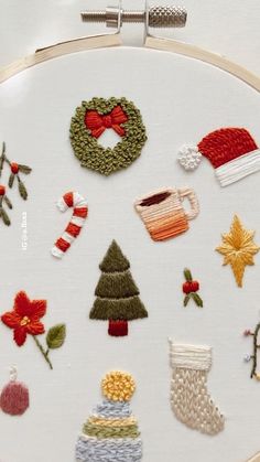 a close up of a embroidery on a white surface with christmas decorations and other items