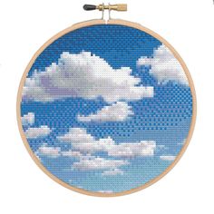 a cross stitch pattern with clouds in the sky