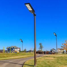 a street light on the side of a road in front of some houses and trees