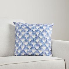 a blue and white pillow sitting on top of a couch