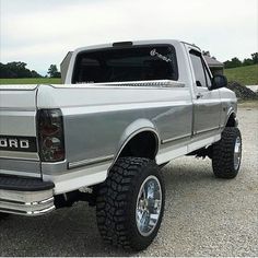 a silver truck parked on top of a gravel road