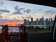 a person taking a photo with their cell phone in the back seat of a car