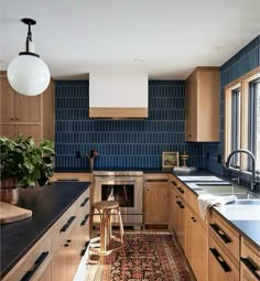 a kitchen with wooden cabinets and blue tile backsplash, an area rug on the floor