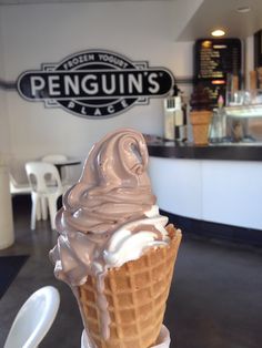 an ice cream sundae with chocolate icing in a waffle cone at penguin's place