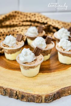 mini desserts with whipped cream and chocolate on a wooden platter