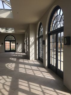 an empty hallway with arched windows and doors