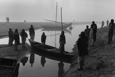 a group of people standing next to a body of water