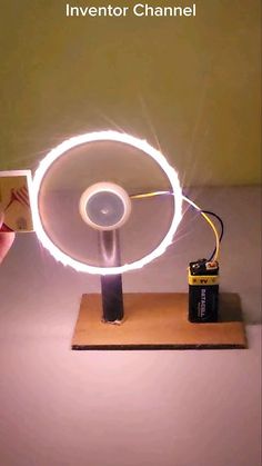 a person is holding up a light that looks like a spinning device with wires attached to it