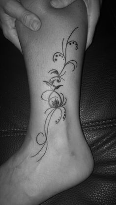 a woman's foot with a flower tattoo on it