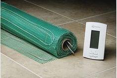 an electronic thermometer sitting next to a roll of green gauzed wire