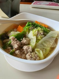 a white bowl filled with meat and vegetables