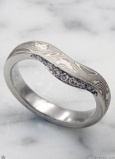 This wedding band stands out on its own with its one-of-a-kind pattern of mokume. Complimenting the natural pattern of the mokume, the band has a beautiful contoured curve. At the heart of this ring, a collection of bead-set stones adds a little shimmer to your day. The contoured shape of this wedding band makes it perfect to compliment any engagement ring. Mokume Gane Ring Wedding, Mokume Gane Ring, Mokume Gane, Bead Set, Diamond Wedding Band, Patterns In Nature, Ring Wedding, The Natural, Diamond Wedding Bands