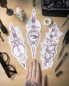 a person's hand with tattoos on it next to some scissors and other items