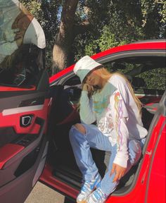 a person sitting in the back of a red car