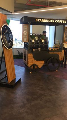 a small coffee cart with a clock on the front and side, in an office building