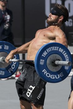 a man with no shirt lifting a barbell