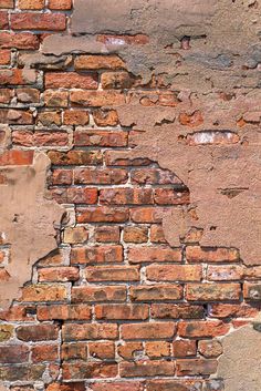 an old brick wall with peeling paint on it