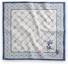 a blue and white table cloth with flowers on the border, in front of a white background