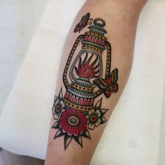 a tattoo on the leg of a person with flowers and a bird in a cage