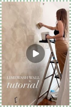 a woman painting a wall with a paint roller