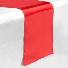 a red and white table runner is on top of a white table with a black border