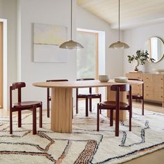 a dining room table and chairs with a rug on the floor