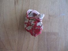 a small red and white flowered bag on a wooden floor