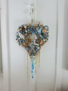 a wreath hanging from the side of a door with beads and chains attached to it