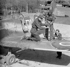 an old black and white photo of men working on a plane