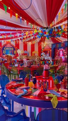 a brightly colored circus themed party with tables and chairs