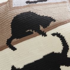 a crocheted blanket with black cats on it