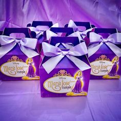 four purple bags with white bows on them